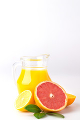 Fresh orange juice and citrus fruits lime lemon grapefruit in a jar white background healthy concept
