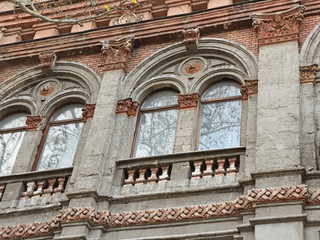 Obraz premium Clustered windows with relieving arches above them adorned with lion heads in round medallions in an old building on Soborna Street, Mykolaiv City, Ukraine