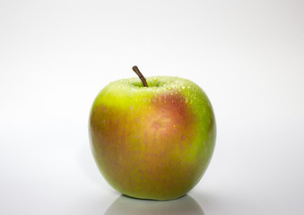 A red and green apple with water drops isolated on a white background.