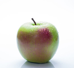 A red and green apple with water drops isolated on a white background.