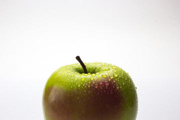 A red and green apple with water drops isolated on a white background.