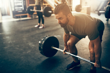 Fit young man preparing to lift weights during a workout