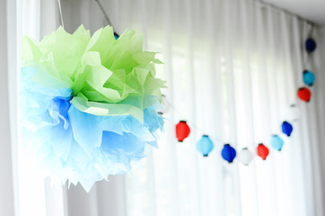 Multi-coloured kids birthday party Rainbow themed. Hanging decorations with paper lights.