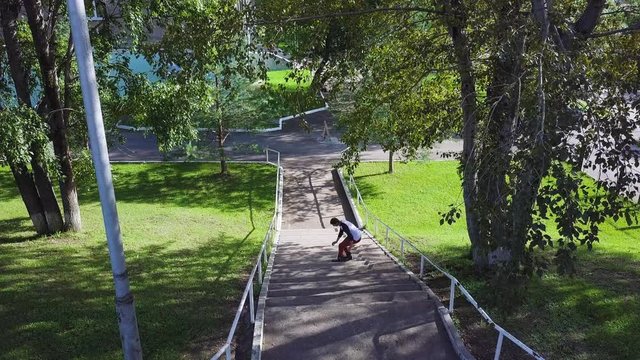 Back view on Roller prepare for high jumping in park. Clip. Roller jumps on railing in the park