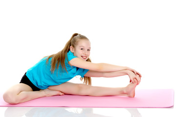 Obraz na płótnie Canvas The little gymnast perform an acrobatic element on the floor.