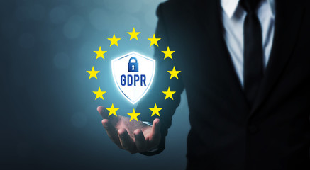 Businessman hand holding sign general data protection regulation (GDPR) and shield with key icon