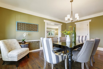 Light olive dining room features a wood carved dining table.