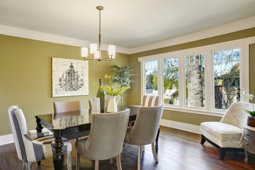 Light olive dining room features a wood carved dining table.
