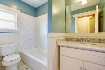 Fototapeta na wymiar White and blue bathroom witth marble-topped vanity.