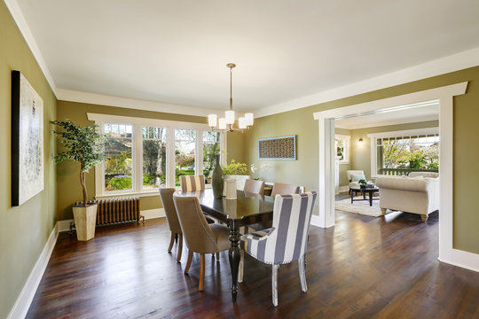 Light olive dining room features a wood carved dining table.