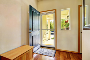 Small foyer with green open front door,