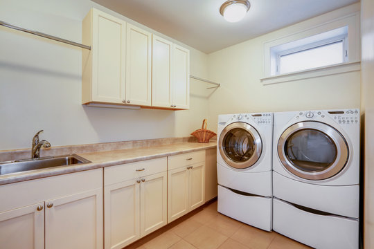 Light laundry room with creamy cabinets.