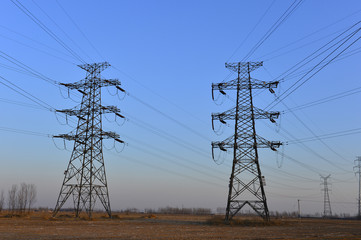 Fototapeta premium The silhouette of the evening electricity transmission pylon