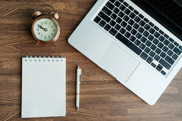 Wooden office desk. Top view with computer notebook and clock Pencil paper