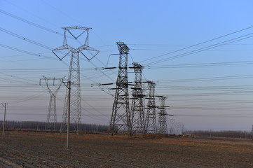 The silhouette of the evening electricity transmission pylon