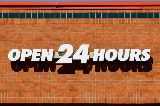 White Open 24 Hours signage against brick background I