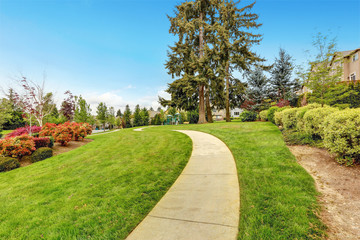 Concrete walkway leading to a park.