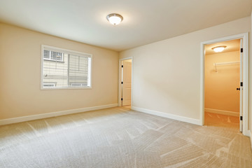 Light empty bedroom interior in beige tones