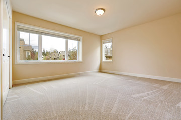 Light empty bedroom interior in soft beige tones