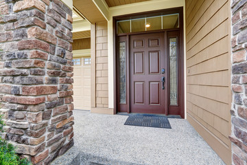 Covered entrance porch boasts front door with ornate sidelights