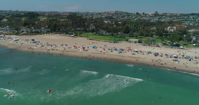 DANA POINT, California. Doheny State Beach. A sunny day beach scene with people engaged in beach activities. Surfers. Aeria 4K