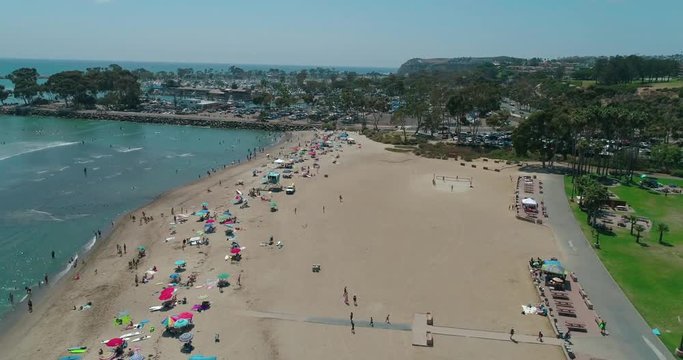 DANA POINT, California. Doheny State Beach. A sunny day beach scene with people engaged in beach activities. Surfers. Aeria 4K