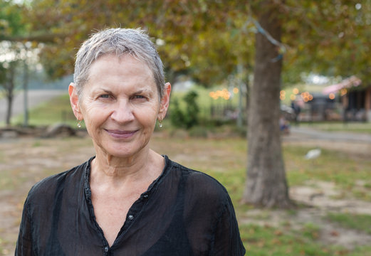 Head And Shoulders View Of Beautiful Older Woman With Short Grey Hair In Park (selective Focus)