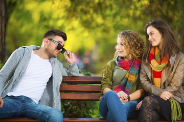 Three young people on a bench flirting