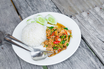 Rice topped with stir-fried minced pork the popular of favorite delicious local Thai food for all meals every day on wooden table