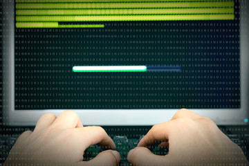 Hands hacker using laptop  at work with download interface around on screen computer