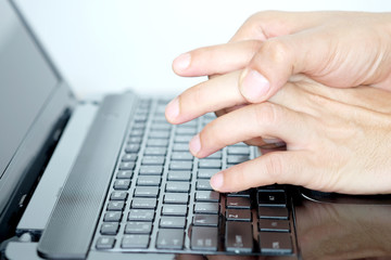 Man have finger pain finger lock to work on a computer keyboard.