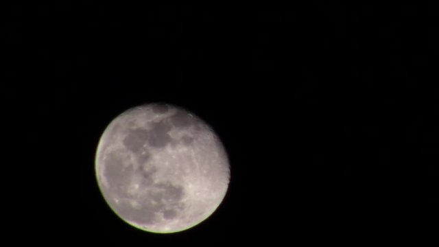 waning gibbous moon in March with passing clouds