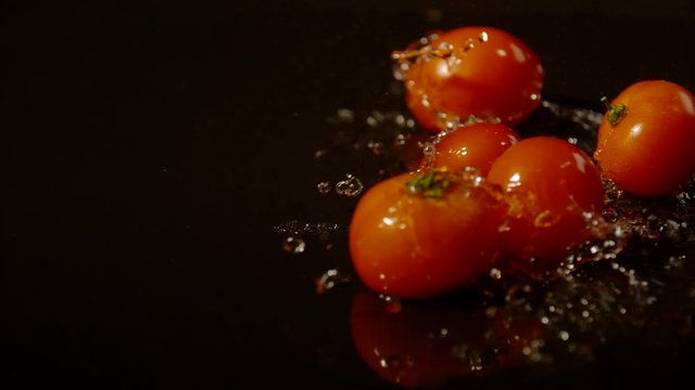 Tomatoes falling and spinning on wet surface, Ultra Slow Motion 