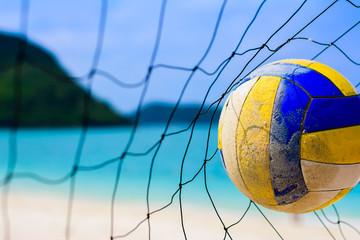 Volleyball hitting to the net on blur beach and blue sea background