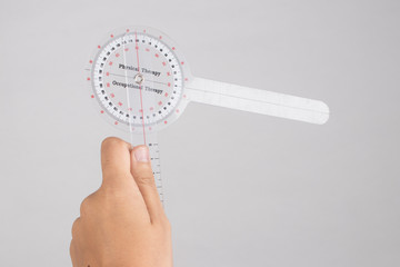physiotherapist holding a goniometer for measuring range of motion isolated on white background. - obrazy, fototapety, plakaty