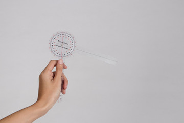 physiotherapist holding a goniometer for measuring range of motion isolated on white background. - obrazy, fototapety, plakaty