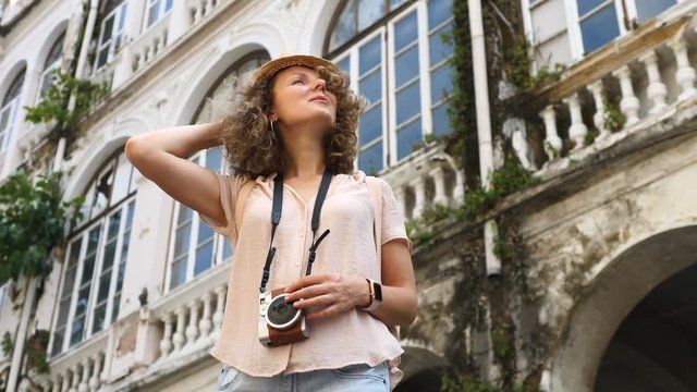Hipster Tourist Girl In Hat Sightseeing With Camera In City On Summer Holidays