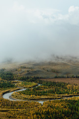 View of the ribbon of the river in the autumn mountain valley