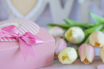 Greeting card with pink gift box, bouquet of tulips on white background