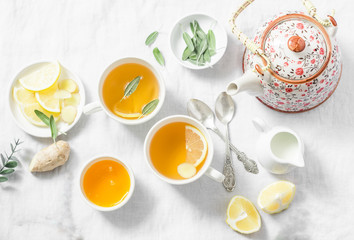 Cough tea. Green tea with lemon, ginger, sage on a light background, top view. Healthy detox drink. Flat lay