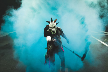 Naklejka premium scary mask with smoke grenade in the middle of the street