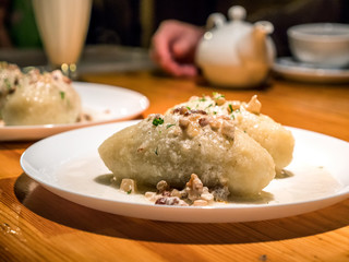 Closeup view of plate with Lithuanian cuisine Ceppelins on it on wooden table © Jevanto Protography