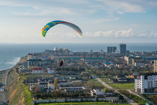 Flying tandem paragliders over the city on a Sunny day