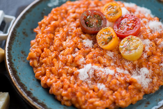Risotto with tomatoes topped with grated parmesan, selective focus, close-up