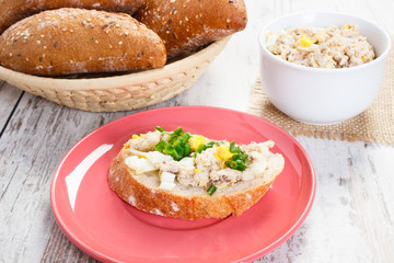 Mackerel or tuna fish paste sandwiches and fresh rolls in background