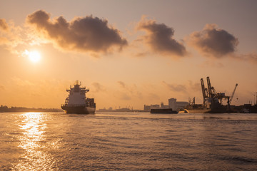 Cargo ship is sailing out of the harbor at evening to sea to transport cargo in the container.Logistics and transportation of International, Freight Transportation, Shipping