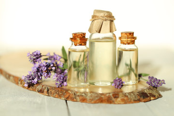 Essential lavender oil. Lavender oil set in bottles and sprigs of fresh lavender on a wooden cut on a gray  background. Botanical cosmetic