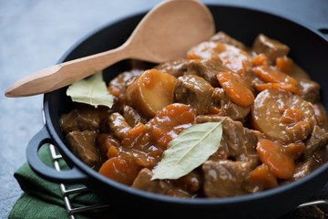 Closeup of a cast-iron pan with Irish beef and beer stew, selective focus, studio shot