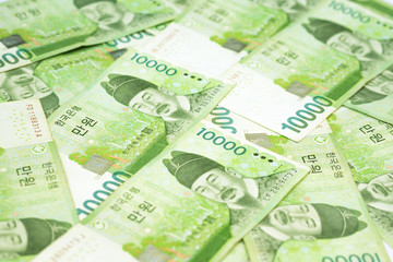 10000 Korea won bills on table as money background. South Korean Republic Won is national currency of South Korea.