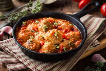 Crédence de cuisine en verre imprimé Viande Meatballs in tomato sauce with dried oregano in a rustic vintage cast iron skillet